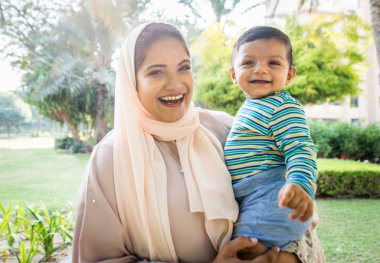 Arap anne ve küçük bebeği dışarıda oynuyorlar.