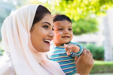 Arap anne ve küçük bebeği dışarıda oynuyorlar.