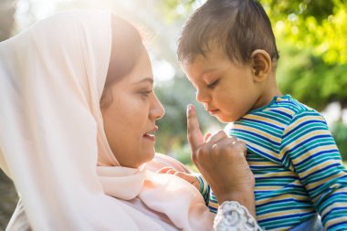 Arap anne ve küçük bebeği dışarıda oynuyorlar.