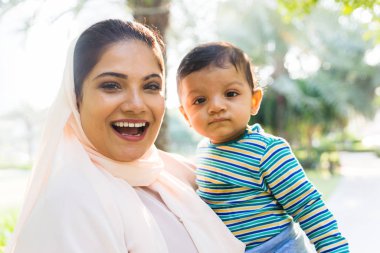 Arap anne ve küçük bebeği dışarıda oynuyorlar.