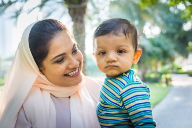 Arap anne ve küçük bebeği dışarıda oynuyorlar.