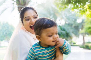 Arap anne ve küçük bebeği dışarıda oynuyorlar.