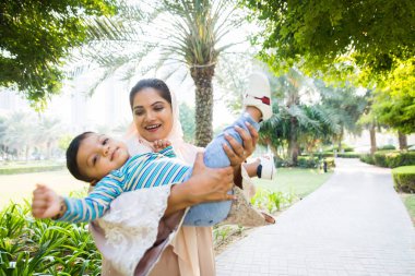 Arap anne ve küçük bebeği dışarıda oynuyorlar.