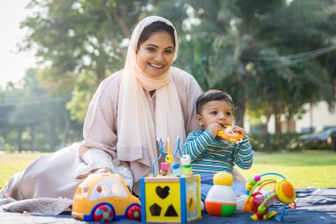 Arap anne ve küçük bebeği dışarıda oynuyorlar.