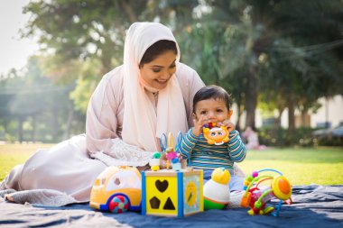 Arap anne ve küçük bebeği dışarıda oynuyorlar.
