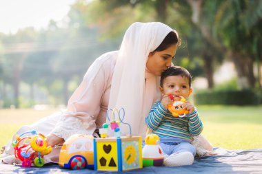 Arap anne ve küçük bebeği dışarıda oynuyorlar.