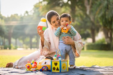 Arap anne ve küçük bebeği dışarıda oynuyorlar.