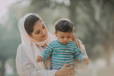 Arap anne ve küçük bebeği dışarıda oynuyorlar.