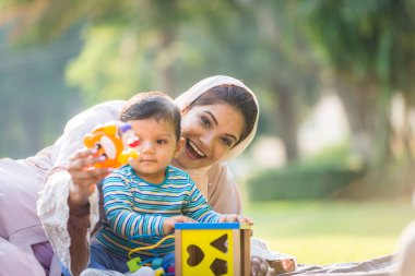Arap anne ve küçük bebeği dışarıda oynuyorlar.