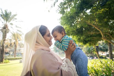 Arap anne ve küçük bebeği dışarıda oynuyorlar.
