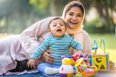 Arap anne ve küçük bebeği dışarıda oynuyorlar.