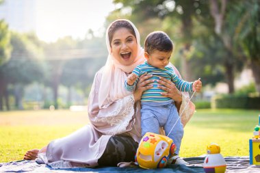 Arap anne ve küçük bebeği dışarıda oynuyorlar.
