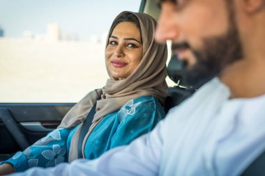 Arabic couple driving in a car clipart