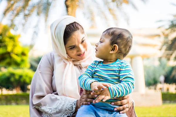 Arap anne ve küçük bebeği dışarıda oynuyorlar.