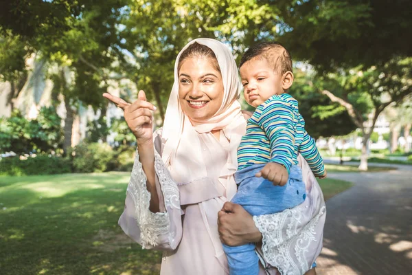 Arap anne ve küçük bebeği dışarıda oynuyorlar.