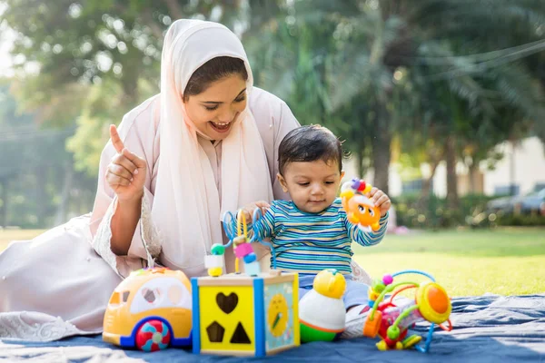 Arabiska mamma och hennes lilla barn leker utomhus — Stockfoto