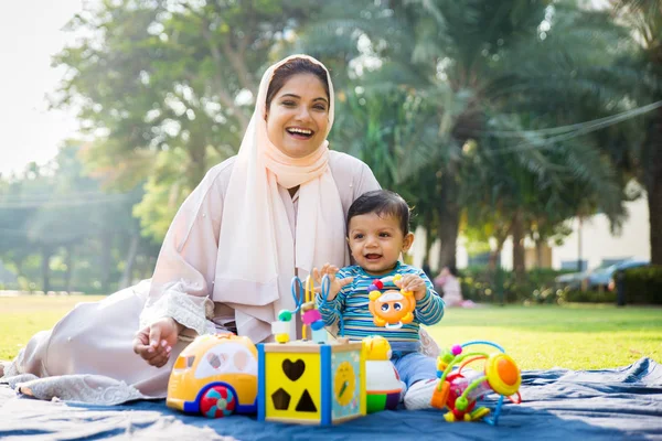 Árabe mãe e sua pequena criança brincando ao ar livre — Fotografia de Stock