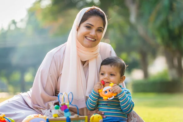 Arap anne ve küçük bebeği dışarıda oynuyorlar.