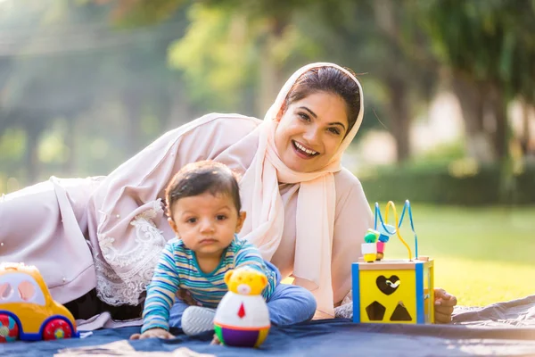 Árabe mãe e sua pequena criança brincando ao ar livre — Fotografia de Stock