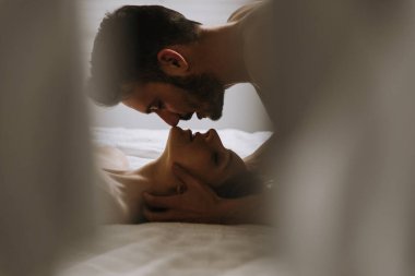 Genç çift yatakta dinleniyor ve eğleniyor.. 