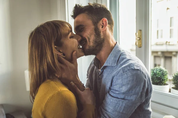 Mladý pár tráví spolu čas doma. Muž a žena kissi — Stock fotografie