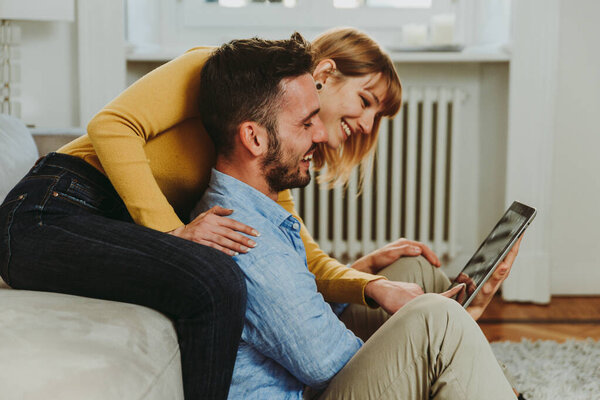 Young couple spending time together at home. Man and woman sitti