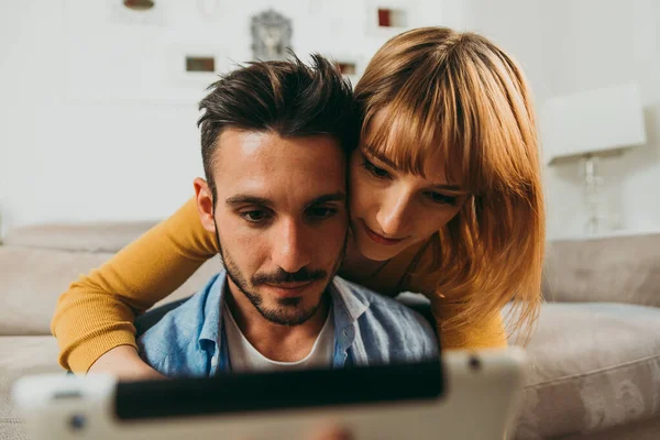 Unga par umgås hemma. Man och kvinna sitti — Stockfoto