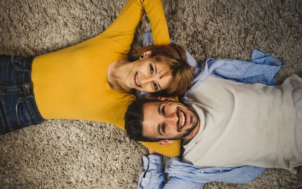 Young couple spending time together at home. Man and woman lying — Stock Photo, Image