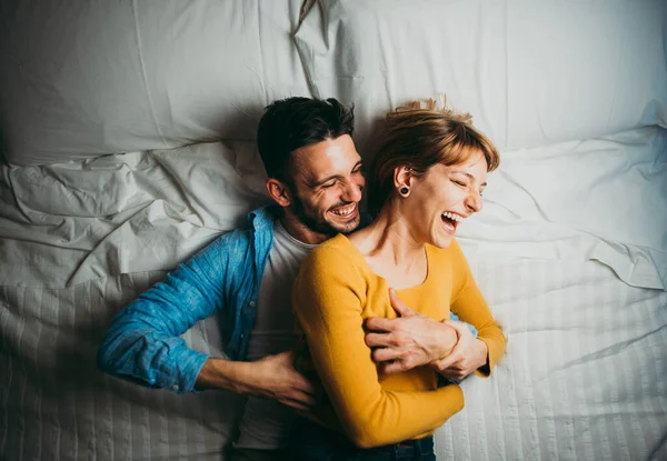 Jovem casal relaxante na cama e se divertindo . — Fotografia de Stock