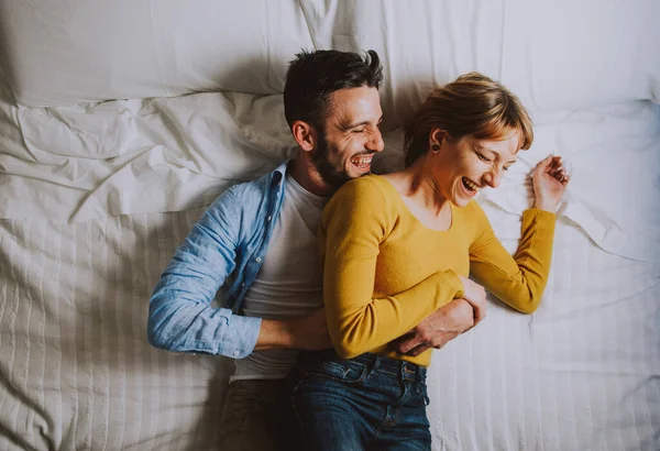 Young couple relaxing in bed and having fun. — Stock Photo, Image