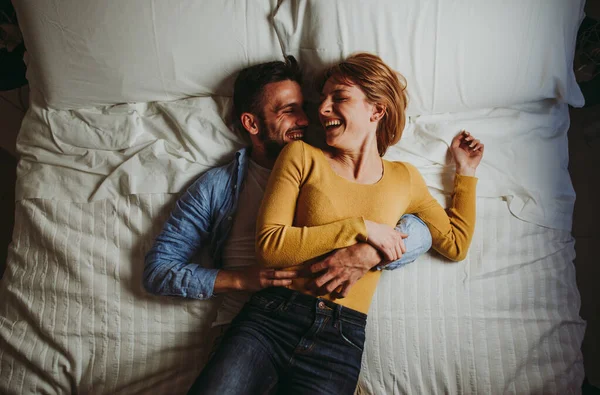 Jovem casal relaxante na cama e se divertindo . — Fotografia de Stock