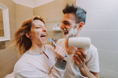 Two young adults at home - Beautiful couple having fun in the bathroom clipart