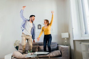 Evde iki yetişkin, iki aşık kanepede eğleniyor.