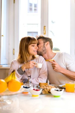 Evde iki genç yetişkin, sabahları kahvaltı yapan güzel bir çift.