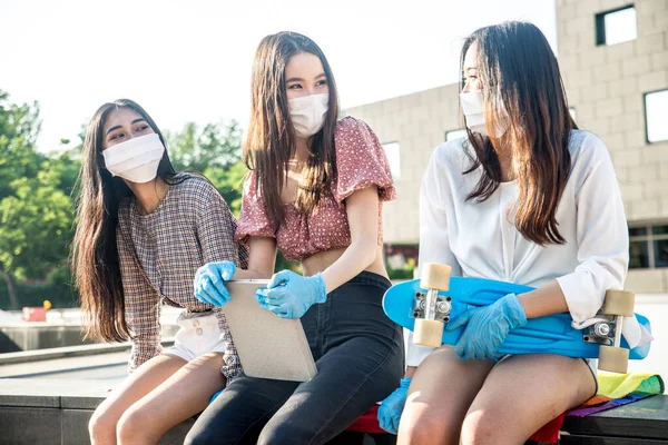 Group of asian girls going out after quarantine during coronavirus period. Young women outdoor with safety masks