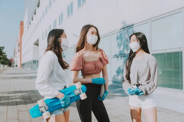 Group of asian girls going out after quarantine during coronavirus period. Young women outdoor with safety masks