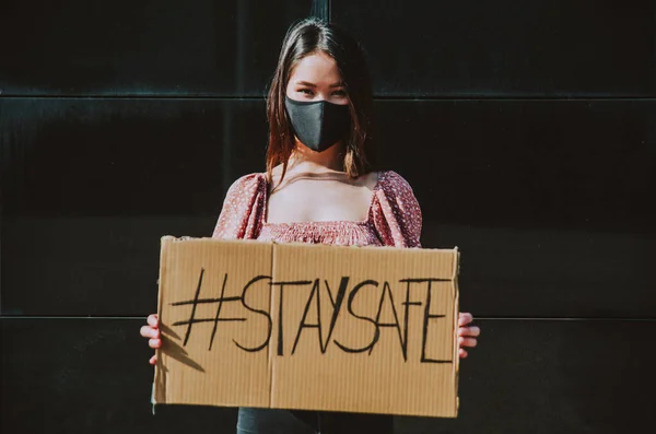 Young Women Outdoor Safety Masks Showing Banners Covid19 Most Popular — Stock Photo, Image