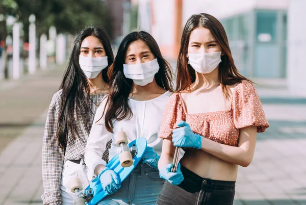 Group of asian girls going out after quarantine during coronavirus period. Young women outdoor with safety masks