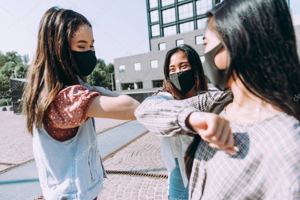 Group of asian girls going out after quarantine during coronavirus period. Young women outdoor with safety masks