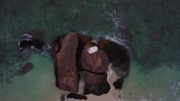 Matrimonio alle Seychelles. Gli amanti dopo la cerimonia sono seduti sulla roccia vicino alla spiaggia Drone colpo 4K — Video Stock