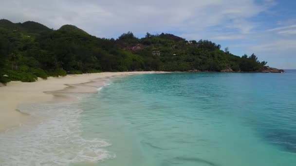 Deniz kıyısı Seyşelleri bulutlu bir günde Grand Anse 4k manzaralı beyaz kum üzerinde uçuyor. — Stok video