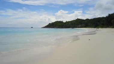 Seyşeller plajı boyunca temiz Hint okyanus dalgaları ve bitkilerle güzel bir manzara daha.