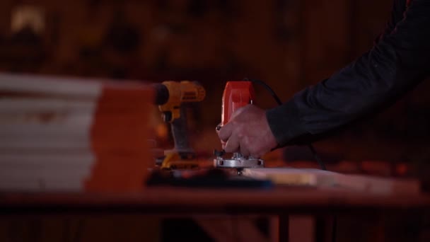 Blanke man werkt als fraser op een houten blanco in een fabriek in rood licht — Stockvideo