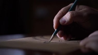 İnsan, gelecekteki ahşap mobilyaların tasarımını karanlık odadaki konsantrasyon için lüks bir şekilde çizer. 4K 'lık yakın çekim görüntüsü.