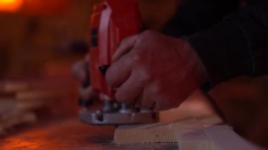 Yakın çekim beyaz adam fabrikanın düşük açılı çekimlerinde boş bir tahta üzerinde fresk olarak çalışıyor.