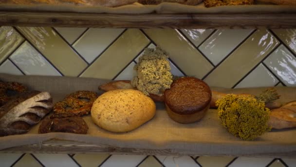 Close-up Pães e produtos de padaria grande variedade em prateleiras de padaria com pão crocante fresco pão integral orgânico alimentos bio trigo 4K — Vídeo de Stock