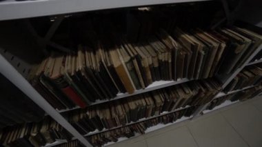 Kütüphanedeki raflarda çok eski kitaplar var.