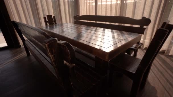 Niesamowite ustawienie stołu i ławek w komfortowym pomieszczeniu z naturalnym światłem. Kamera porusza się w kontroli ruchu w rozdzielczości 4K — Wideo stockowe