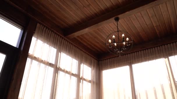 2つの珍しいシャンデリアと大きな窓が付いている美しい未処理の天井は自宅で非常に快適な雰囲気を作ります。4K映像 — ストック動画