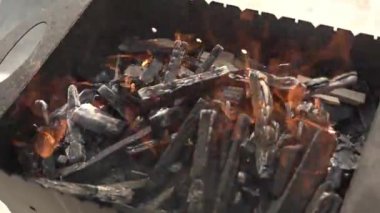 Aşçı ızgarada barbeküyle şiş bırakıyor.